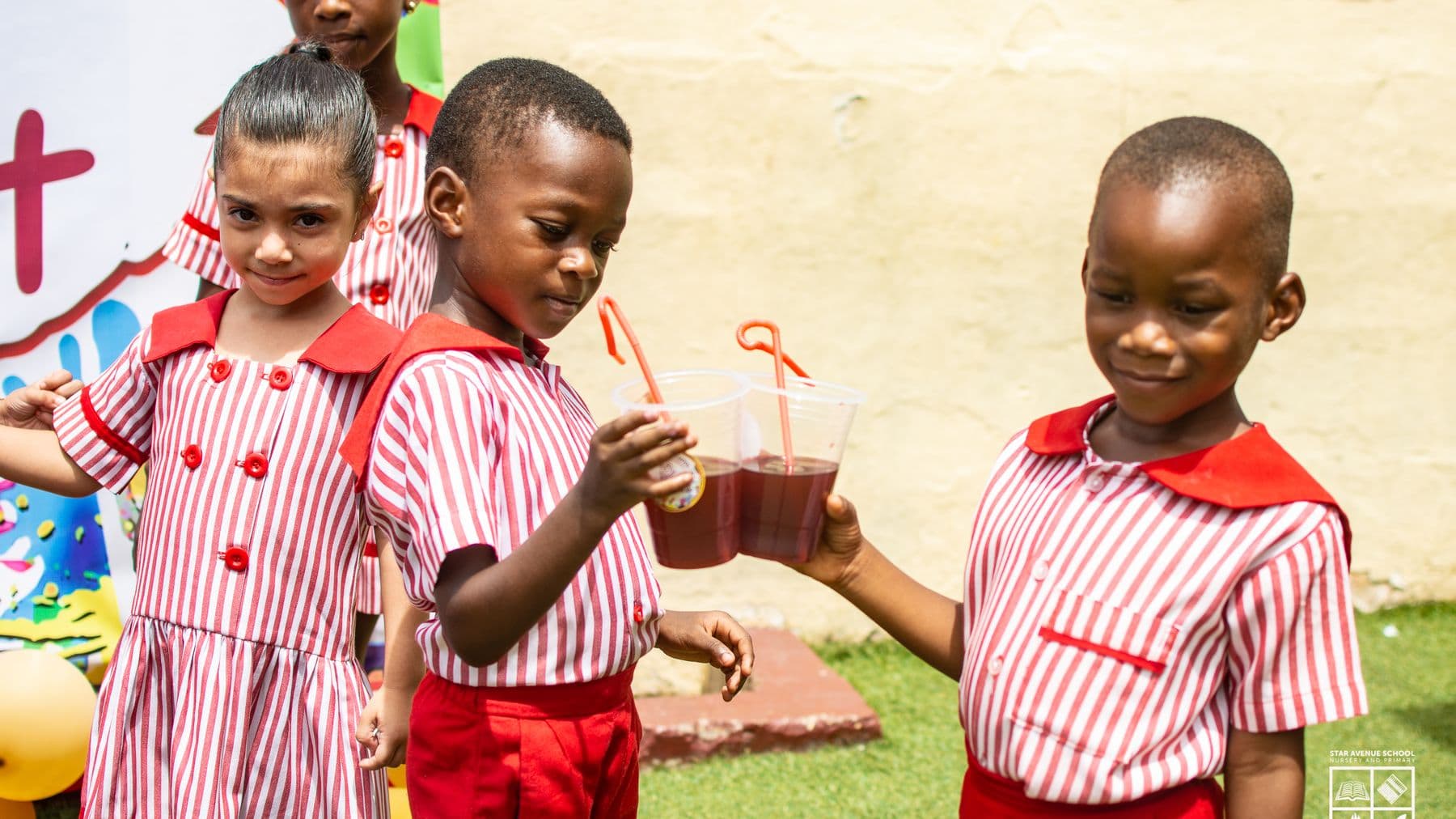 Pupils drinking juice together at break in the courtyard
