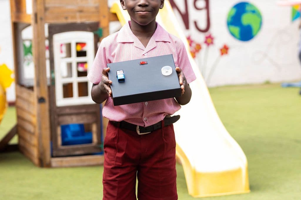 A pupil holding a tablet in the school playground