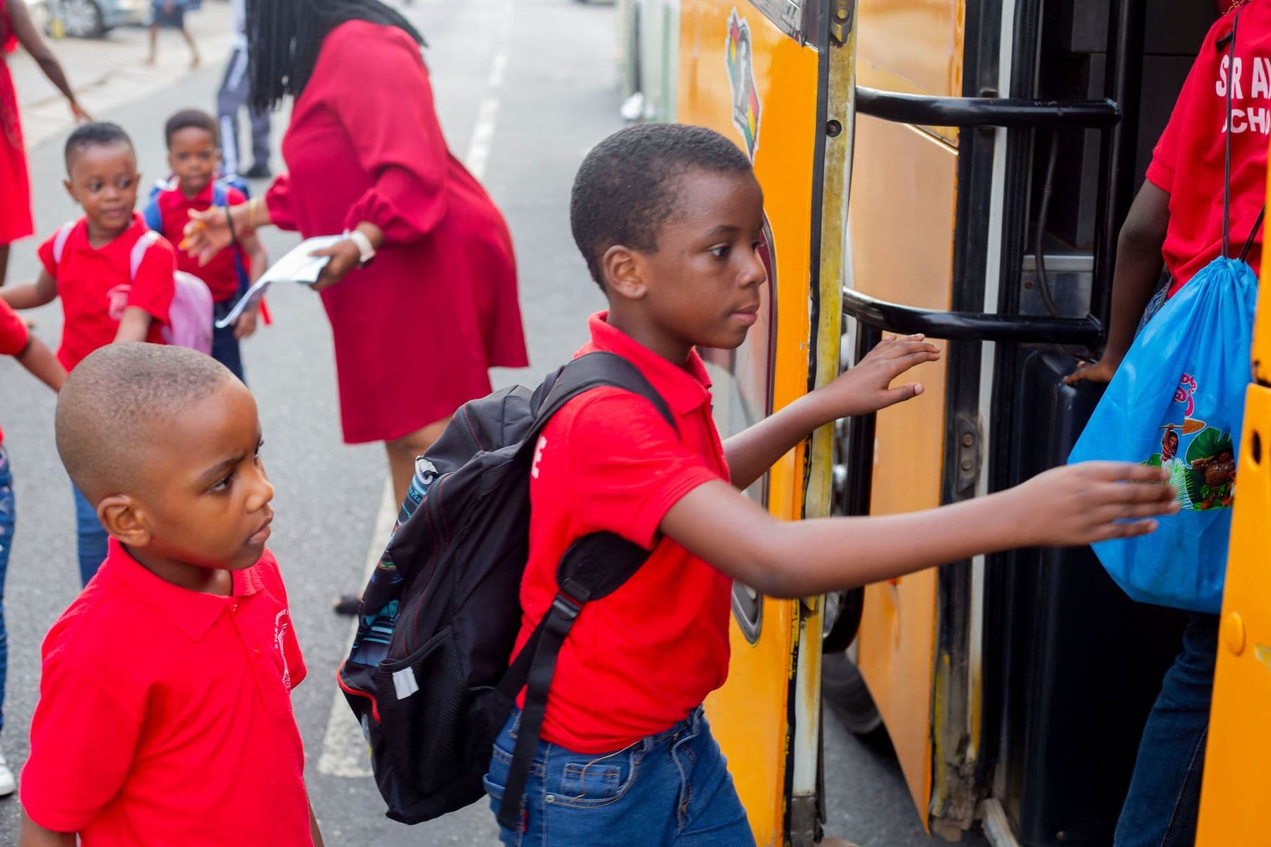Pupils with backpacks arriving at the classroom door in the morning